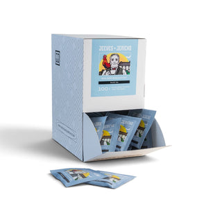 A light blue and white Jeeves & Jericho 100-count display box with several individual packets displayed in the front slot and two packets placed in front, on a clean white background.