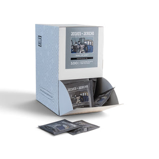A light blue and white display box containing multiple black sachets labelled 'Jeeves + Jericho' and '100 PACK', shown on a clean white background with two sachets placed in front.