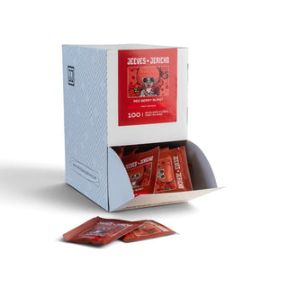 A light blue and white cardboard display box labelled 'Jeeves + Jericho' with red sachets visible inside and two red sachets placed in front, photographed on a clean white background.